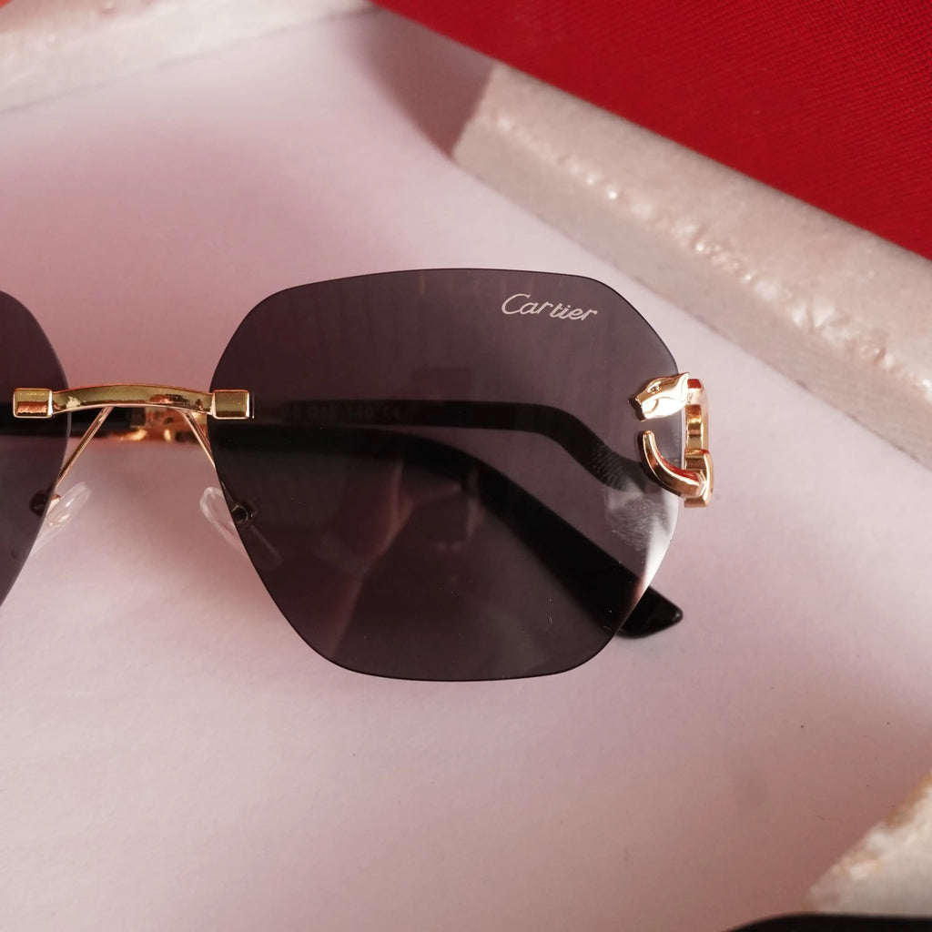 Rimless gold panther black sunglasses - flat lay top view with Cartier cleaning cloth